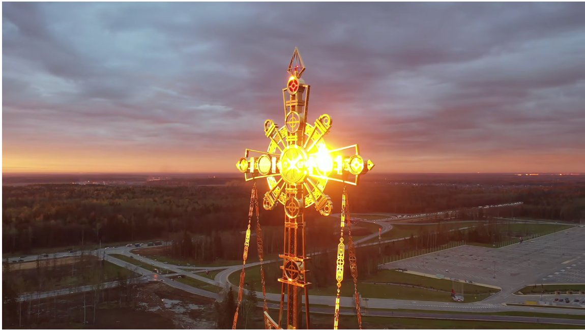 教堂屋頂的十字架迎著夕陽散發美麗光芒。（圖／影片截圖）